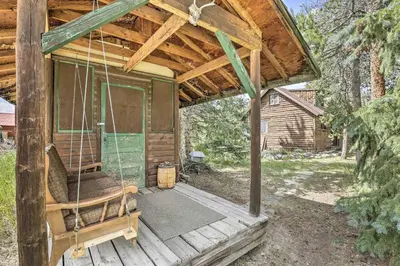 a porch of a cabin with a porch swing at Walk to Grand Lake Historic Dtwn Cabin! in Grand Lake