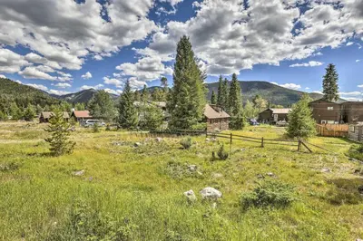 a field of grass with houses and trees at Walk to Grand Lake Historic Dtwn Cabin! in Grand Lake