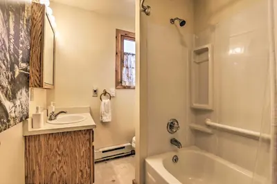 a bathroom with a sink and a tub and a toilet at Walk to Grand Lake Historic Dtwn Cabin! in Grand Lake