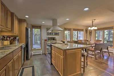 a large kitchen with wooden cabinets and a large island at Creekside Frisco Condo with Views and Pool Access! in Frisco