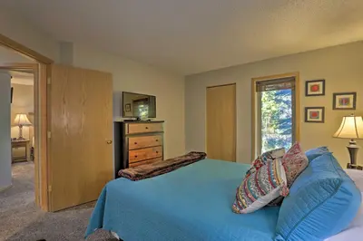 a bedroom with a blue bed with a dresser and a television at Creekside Frisco Condo with Views and Pool Access! in Frisco
