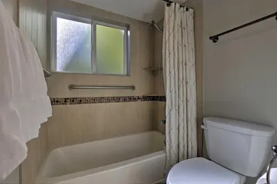 a bathroom with a tub and a toilet and a window at Creekside Frisco Condo with Views and Pool Access! in Frisco
