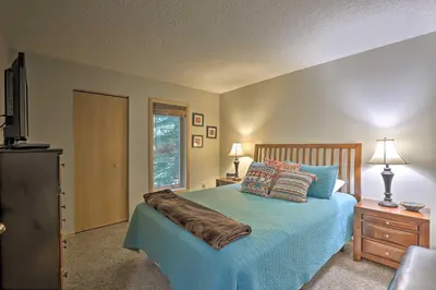 a bedroom with a bed with a blue comforter at Creekside Frisco Condo with Views and Pool Access! in Frisco