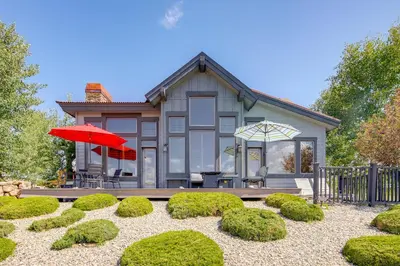 a house with a red umbrella and some bushes at Grand Elk Golf Club On-Site Mtn-View Home with Deck in Granby
