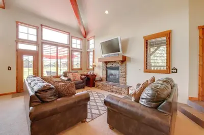 a living room with leather furniture and a fireplace at Grand Elk Golf Club On-Site Mtn-View Home with Deck in Granby