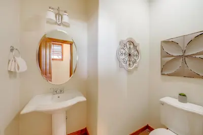 a bathroom with a sink and a mirror and a toilet at Grand Elk Golf Club On-Site Mtn-View Home with Deck in Granby