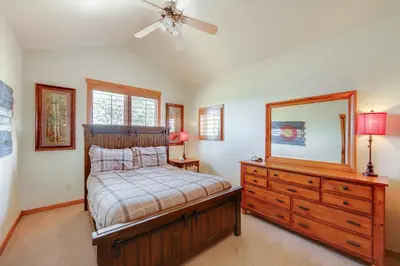 a bedroom with a bed and a dresser and a mirror at Grand Elk Golf Club On-Site Mtn-View Home with Deck in Granby