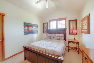 a bedroom with a bed and a table and a window at Grand Elk Golf Club On-Site Mtn-View Home with Deck in Granby