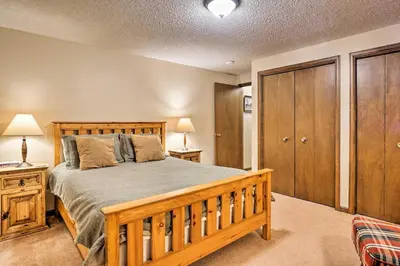 a bedroom with a wooden bed and wooden cabinets at Peaceful Pines Estes Park Home Longs Peak View in Estes Park