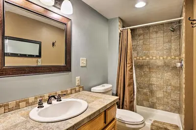 a bathroom with a sink and a toilet and a mirror at Peaceful Pines Estes Park Home Longs Peak View in Estes Park