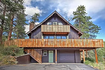 a house with a deck and a garage at Peaceful Pines Estes Park Home Longs Peak View in Estes Park