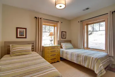 a bedroom with two beds and a window at Charming Estes Park Cabin with 2 Private Patios! in Estes Park