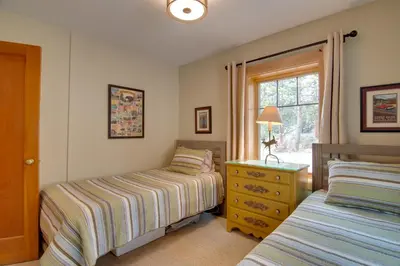 a bedroom with two beds and a window at Charming Estes Park Cabin with 2 Private Patios! in Estes Park