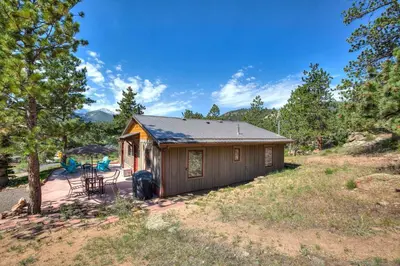 a small cabin with a porch and a patio at Charming Estes Park Cabin with 2 Private Patios! in Estes Park
