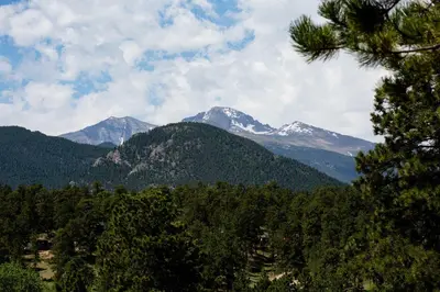 a mountain range with snow capped mountains in the distance at Charming Estes Park Cabin with 2 Private Patios! in Estes Park