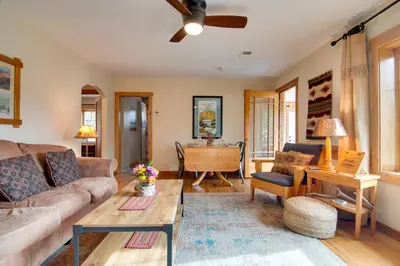 a living room with a couch and a table at Charming Estes Park Cabin with 2 Private Patios! in Estes Park