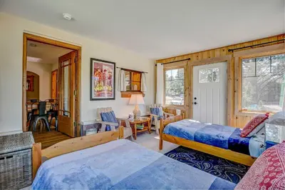 a bedroom with two beds and a table and chairs at Charming Estes Park Cabin with 2 Private Patios! in Estes Park