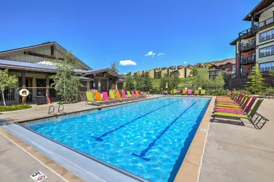 a large swimming pool with colorful chairs in a building at Patio, Fire Pit, and Ski Mountain View Granby Home in Granby