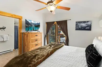 a bedroom with a bed and a ceiling fan at Updated and Spacious Lodge in Heart of Estes Park! in Estes Park