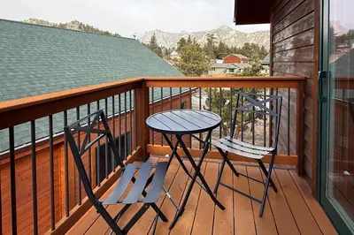 two chairs and a table on a balcony at Updated and Spacious Lodge in Heart of Estes Park! in Estes Park