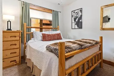 a bedroom with a bed and a dresser and a window at Updated and Spacious Lodge in Heart of Estes Park! in Estes Park