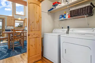 a kitchen with a washer and dryer and a table at Updated and Spacious Lodge in Heart of Estes Park! in Estes Park