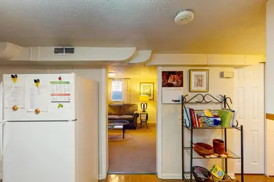 a kitchen with a refrigerator and a living room at Elati Guesthouse Walkable Home in Arts District in Denver