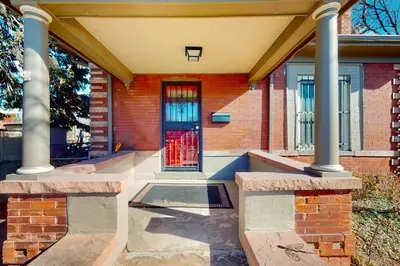 a brick building with a red door and columns at Elati Guesthouse Walkable Home in Arts District in Denver