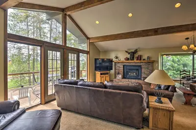 a living room with a couch and a fireplace at Sprawling Fraser Cabin with Private Hot Tub and Deck! in Fraser