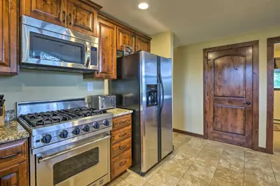 a kitchen with a stainless steel stove and refrigerator at Sprawling Fraser Cabin with Private Hot Tub and Deck! in Fraser