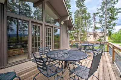 a patio with a table and chairs on a deck at Sprawling Fraser Cabin with Private Hot Tub and Deck! in Fraser