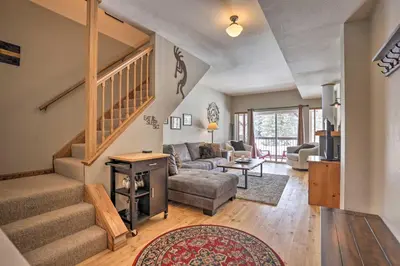 a living room with a couch and a staircase at Pet-Friendly Fraser Condo with Community Hot Tub in Fraser