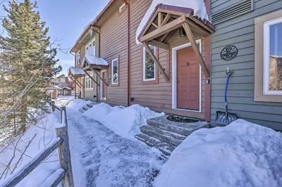 a house is covered in snow with a driveway at Pet-Friendly Fraser Condo with Community Hot Tub in Fraser