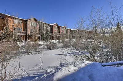 a building with snow in front of it at Pet-Friendly Fraser Condo with Community Hot Tub in Fraser