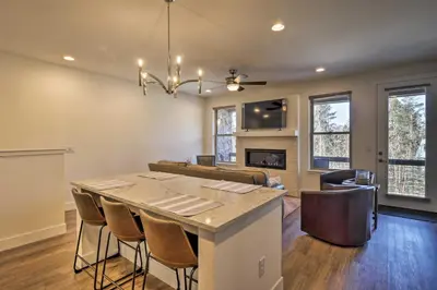 a kitchen and living room with a table and chairs at Mountain Escape with Hot Tub Less Than 5 Mi to Winter Park! in Fraser