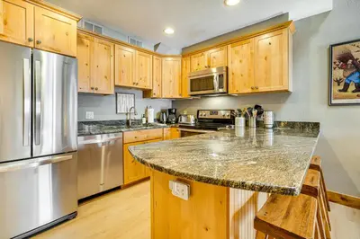 a kitchen with wooden cabinets and a granite counter top at Ski and Relax Fireside Frisco Gem with Resort Perks! in Frisco