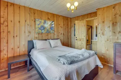 a bedroom with a bed in a room with wooden walls at Panoramic Mountain-View Retreat with Hot Tub and Deck! in Tabernash