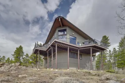 a house on top of a hill at Panoramic Mountain-View Retreat with Hot Tub and Deck! in Tabernash