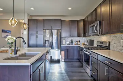 a kitchen with wooden cabinets and a sink and a refrigerator at 3 Mi to Granby Ranch Expansive Granby Retreat! in Granby
