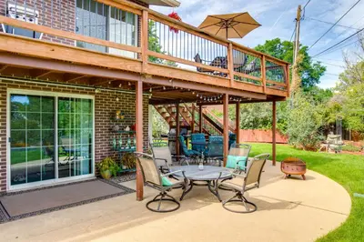 a patio with a deck and a table and chairs at Modern Creekside Home 9 Mi to Downtown Denver in Lakewood