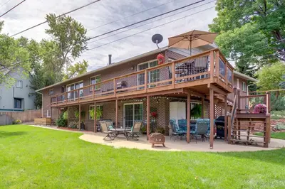 a large house with a deck and a patio at Modern Creekside Home 9 Mi to Downtown Denver in Lakewood