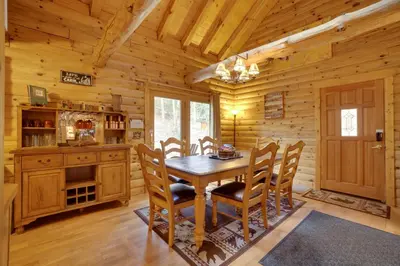 a dining room with a wooden table and chairs at Picturesque Log Cabin in Estes Park 9 Mi to RMNP in Estes Park