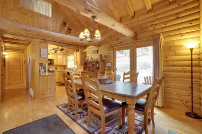 a dining room with a wooden table and chairs at Picturesque Log Cabin in Estes Park 9 Mi to RMNP in Estes Park