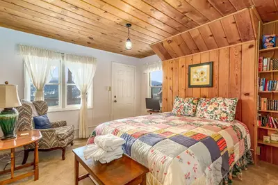 a bedroom with a bed and a chair and a table at Bishop's Retreat in Estes Park