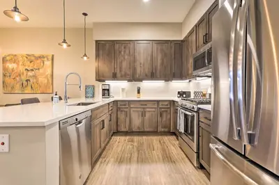 a kitchen with wooden cabinets and a stainless steel refrigerator at Winter Park Condo Proximity to Cafes and Rec Center in Winter Park