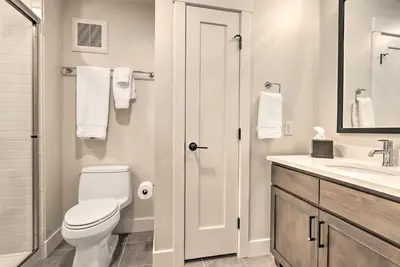 a white bathroom with a toilet and a sink at Winter Park Condo Proximity to Cafes and Rec Center in Winter Park