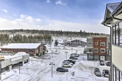 a parking lot covered in snow next to buildings at Winter Park Condo Proximity to Cafes and Rec Center in Winter Park