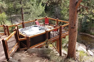 a hot tub on a deck next to a tree at Fall River Hideaway in Estes - 3 Mi to Natl Park! in Estes Park