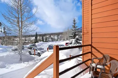 a snow covered porch with a car parked in a parking lot at Timber Ridge Condo in Silverthorne