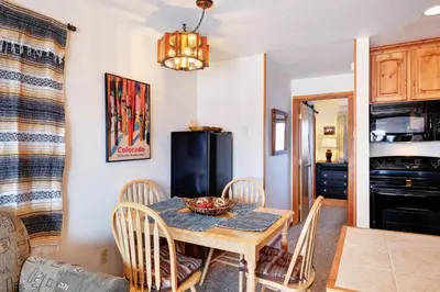a dining room with a table and chairs and a kitchen at Timber Ridge Condo in Silverthorne